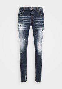 Jeans de mezclilla azul de corte skinny con detalles desgastados, áreas descoloridas y manchas de pintura. Presentan un diseño clásico de cinco bolsillos y cierre de botón.