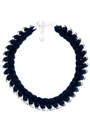 Collier chaîne argentée tressée avec un tissu bleu foncé, fermé par un fermoir homard et un petit charm rond.