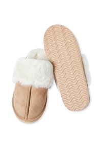 Beżowe zamszowe kapcie z białym sztucznym futrem na mankiecie, gumowa podeszwa z falistym wzorem oraz detalami przeszycia wzdłuż przedniego szwu.