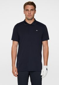 Herrarnas kortärmade pikétröja i marinblått, tillverkad av mjukt tyg med klassisk krage; har en liten logotyp på bröstet och sidodetaljer.