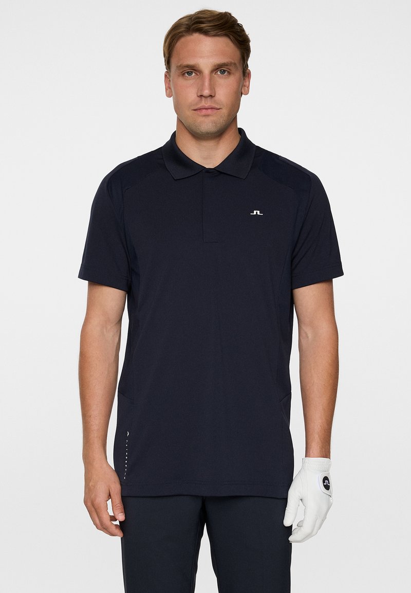 Herrarnas kortärmade pikétröja i marinblått, tillverkad av mjukt tyg med klassisk krage; har en liten logotyp på bröstet och sidodetaljer.