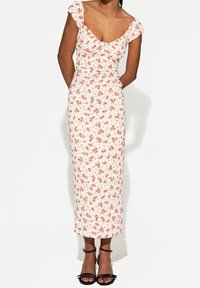 Kukkakuvioinen midi-mekko, jossa on pyöreä pääntie, lyhyet hihattomat hihoja ja vartalonmyötäinen siluetti vaaleassa kankaassa, jossa on pieniä punaisia kukkia. Mustat nauhavadit.