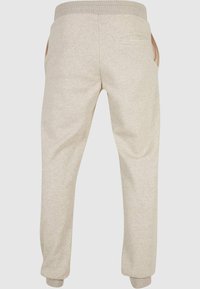Beige sweatpants met een geribbelde tailleband, elastische boorden en zijzakken. Gemaakt van een zachte stof met een gladde textuur en een eenvoudig ontwerp.