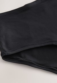 Schwarzer Badeslip aus glattem, elastischem Stoff. Verfügt über saubere Kanten und flache Nähte für Komfort. Leichtes und vielseitiges Design.