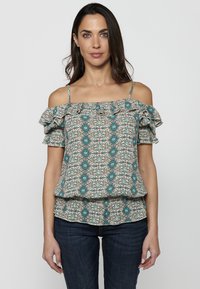 Blusa off-shoulder con motivi, maniche a volant, caratterizzata da design teal e floreali su uno sfondo chiaro. Tessuto leggero e vestibilità comoda.