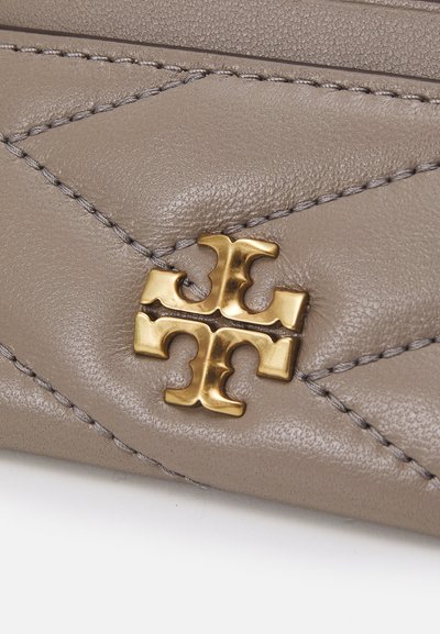 Portefeuille en cuir gris avec un design matelassé, des accessoires logo en or et des coutures contrastées. Texture lisse avec un léger lustre.