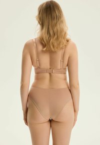 Nude komplet bielizny z bezszwowym designem, regulowanymi ramiączkami i zapięciem na haftkę z tyłu dla łatwego zakładania.