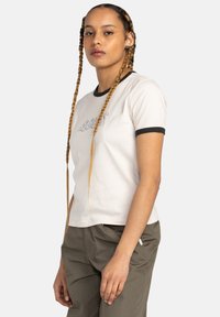 Witte t-shirt met een contrasterende zwarte ringerhals en korte mouwen. Bevat het woord "REBEL" in kleurrijke sierlijke letters op de voorkant.