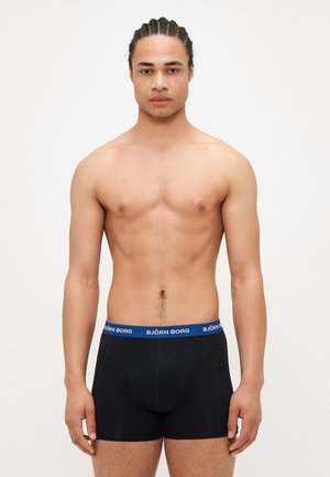 Schwarze Boxershorts mit einem blauen elastischen Bund, der das Logo "BJÖRN BORG" zeigt. Der Stoff wirkt glatt und sitzend.