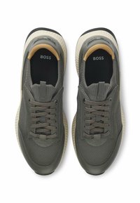 Sneaker in rete grigio con accenti in tessuto e gomma, caratterizzate da una parte superiore testurizzata, lacci e una suola cremosa a contrasto. Logo sulla soletta.