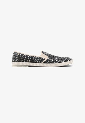 Instapschoen met zwart-wit geweven patroon, beige rand en gestructureerde witte zool met label Leisure Shoes, weergegeven in zijaanzicht op witte achtergrond.