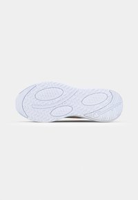 Fehér sneaker talp, texturált tapadási mintákkal, körkörös díszítésekkel és egy kiemelkedő logóval. Rugalmas barázdák növelik a tapadást és a flexibility-t.