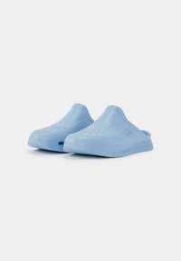 Tamancos azul claro feitos de plástico suave, com um bico arredondado, aberturas laterais para respirabilidade e uma sola texturizada para aderência.