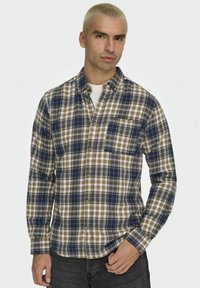 Karierte Hemd in Braun, Blau und Weiß mit langen Ärmeln, Knopfleiste vorne, einer Brusttasche und mitteldicker Stoffstruktur.