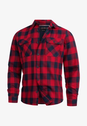 Chemise en flanelle rouge et marine à motif à carreaux, avec deux poches poitrine et un col boutonné. Fabriquée en tissu doux.