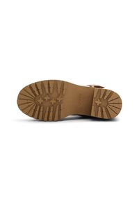 Suela exterior de goma marrón con profundos patrones de dibujo, con una superficie lisa y ligera curva en la punta. Marca visible cerca del talón.