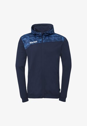 Veste zippée bleu marine avec capuche, empiècement à motif géométrique dans des tons de bleu foncé, deux poches latérales et logo « Kempa » sur la poitrine supérieure.