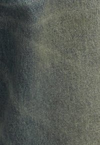 Tecido de denim em verde oliva escuro, com uma textura subtil e padrões de trama visíveis. Sem hardware proeminente ou detalhes adicionais.