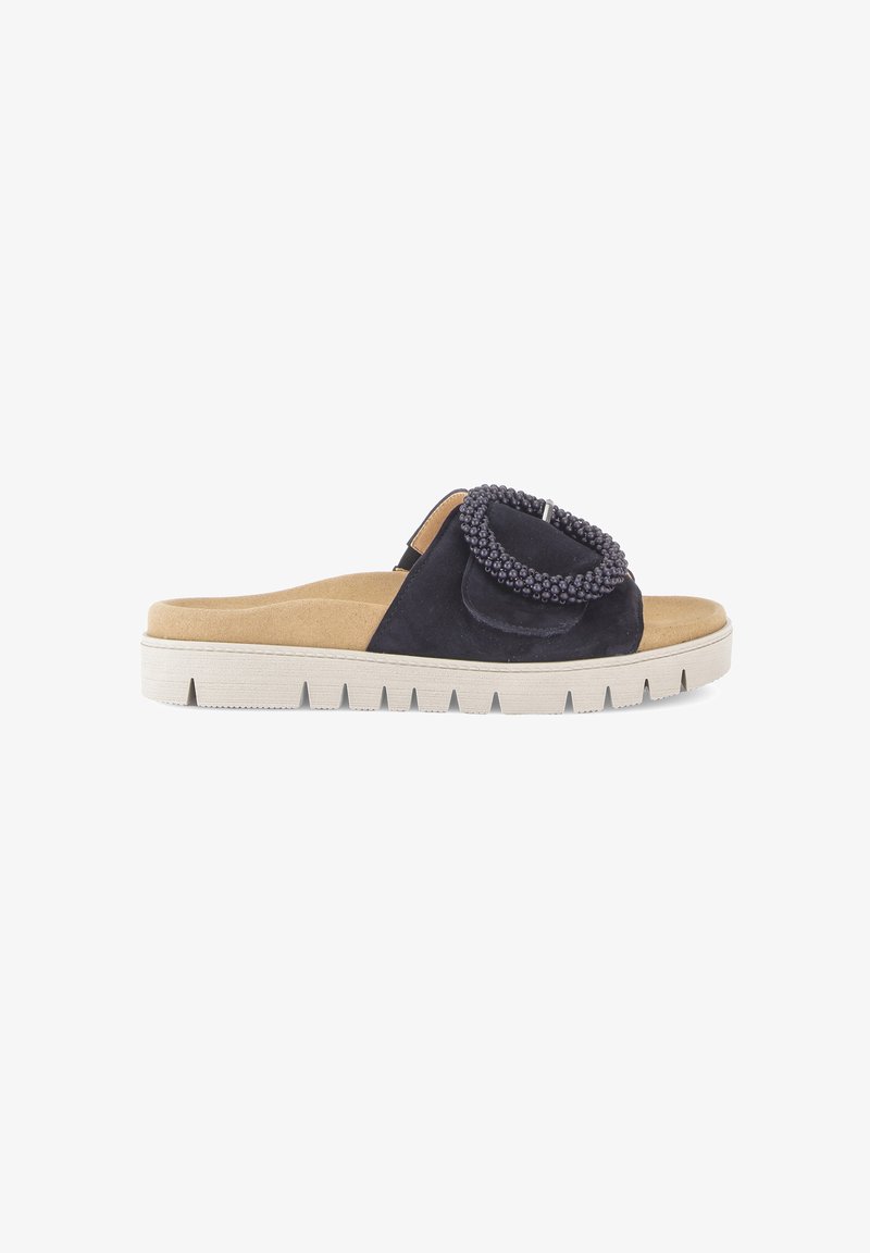 Sandalo slide in camoscio nero con sottopiede sagomato beige, suola bianca spessa e fibbia decorativa a cerchio con perline sulla cinturina.