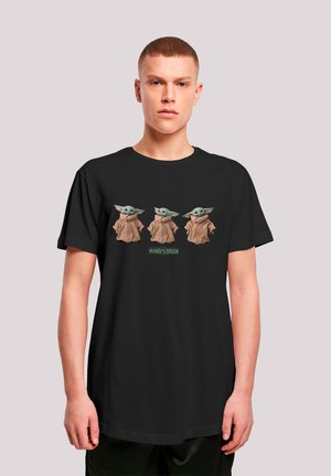 Black t-shirt featuring three green, stylized characters in brown robes. "MANDALORIAN" text appears below the characters.