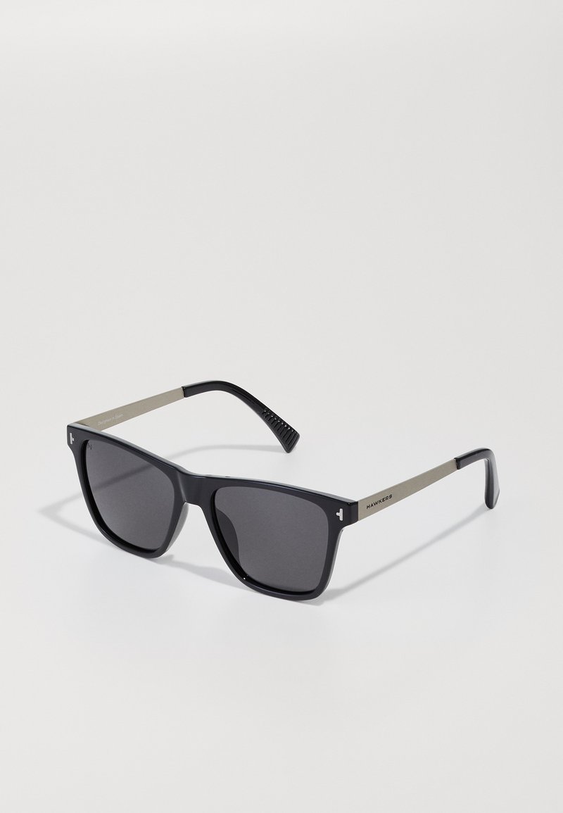 Black rectangular sunglasses with dark lenses and matte silver arms, Hawkers brand visible on the right temple.