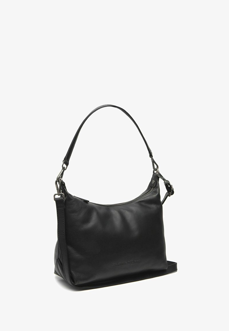 Musta nahkakäsilaukku, jossa on kaareva muoto, yksittäinen olkahihna ja hopeakatteet. Varustettu vetoketjulla ylhäällä. Sileä pinta.