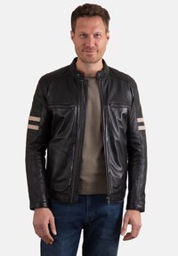 Black leather jacket with a stand-up collar, zippered front, two chest pockets, and beige stripes on the sleeves. Smooth texture and fitted design.