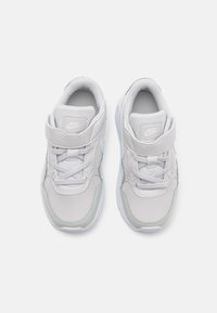 Baskets Nike en maille et cuir gris clair, avec une languette rembourrée, une sangle ajustable et des coutures décoratives, le tout reposant sur une semelle blanche.