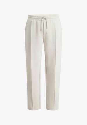 Lichtbeige joggerbroek, gemaakt van zacht stof, met een taillekoord, zijnaden, een ontspannen pasvorm en taps toelopende pijpen.