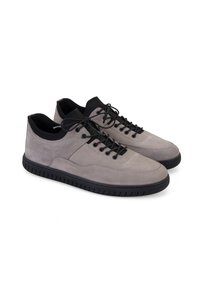 Graue Wildledersneaker mit schwarzen Akzenten, mit einer abgerundeten Zehenkappe, Schnürverschluss und gummierter Laufsohle mit strukturiertem Profil. Minimalistisches Design.