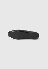 Suela de zapato negra con patrón de agarre texturizado. Presenta un acabado suave y una forma redondeada distintiva. Diseño ligero para mayor comodidad.