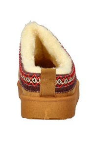 Brown slipper with a textured, rubber sole and a fur-lined interior. Features intricate red, cream, and purple stitching along the top edge.