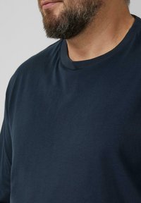 Dunkelblaues Baumwoll-T-Shirt mit Rundhalsausschnitt. Glatte Textur, kurze Ärmel und schlichtes Design ohne Logos oder Muster.