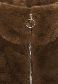 Brun konstpälsjacka med silverfärgad blixtlåsöppning, rund dragkedja och mjuk textur, perfekt för värme och komfort.
