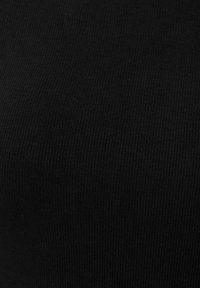 Close-up van zwarte ribstof textuur met verticaal gebreid patroon.