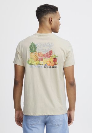 Beige bomulds T-shirt med et farverigt frugt grafik på ryggen, der har teksten "Florida's Finest" og "Shop local SUN CO. FRUIT."