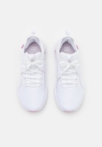 Un par de zapatillas deportivas blancas con acentos rosas, atadas, vistas desde arriba sobre un fondo blanco.