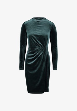 Grünes Samtkleid mit langen Ärmeln, das eine Drehung in der Taille und einen knielangen Schnitt aufweist. Weiche Textur und glatte Verarbeitung.