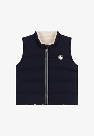 Tengerészkék steppelt mellény cipzárral az elején, texturált polár béléssel és kör alakú logóval a mellrészen. Ujjak nélküli, steppelt kialakítás.