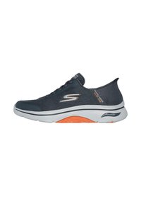 Zapatilla deportiva gris oscuro con material de malla, detalles naranjas y una suela blanca. Presenta una parte superior texturizada y un collar acolchado para mayor comodidad.