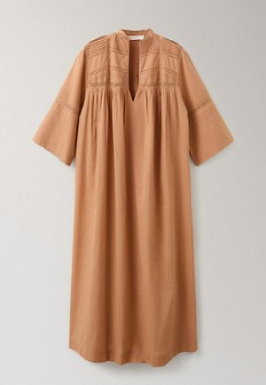 Loose, long tan dress with wide three-quarter sleeves, subtle lace detailing on upper chest and sleeves, and a deep V-neck collar.