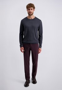 Donkergrijze lange mouwen T-shirt met ronde hals, gecombineerd met maroon tapered broeken en donkerbruine schoenen. Glad materiaal, minimalistisch ontwerp, geen patronen.