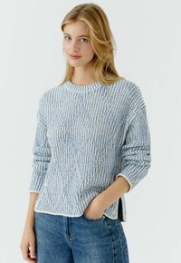 Lichtblauwe en witte gebreide trui met een gestructureerd, diagonaal patroon. Voorzien van een ronde hals, lange mouwen en een iets cropped zoom.