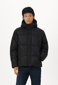 Black puffer jacket with a hood, featuring a zip front, side pockets, and quilted pattern. Smooth texture, designed for warmth and comfort.