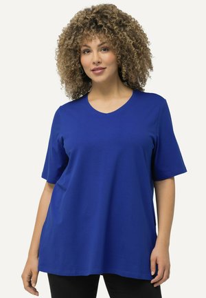 Camisa de algodón azul de manga corta, hecha de un tejido suave, con un diseño de escote en V y un corte holgado, con una textura suave y sin patrones visibles.