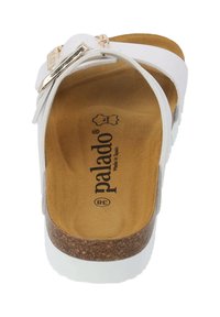 Vit sandal med korksula, gyllene detaljer och ett mjukt, texturerat inre. Har breda remmar och en avslappnad design. Logotyp synlig på innersulan.