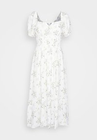 Robe midi blanche à fleurs avec des manches bouffantes, un corsage smocké et une jupe à volants. Présente de petits motifs floraux verts et jaunes.