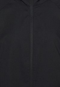 Schwarze Reißverschlussjacke mit glatter Textur, ausgestattet mit einem zentralen Reißverschluss und einer Kapuze. Entworfen mit einem einfachen, stromlinienförmigen Erscheinungsbild.