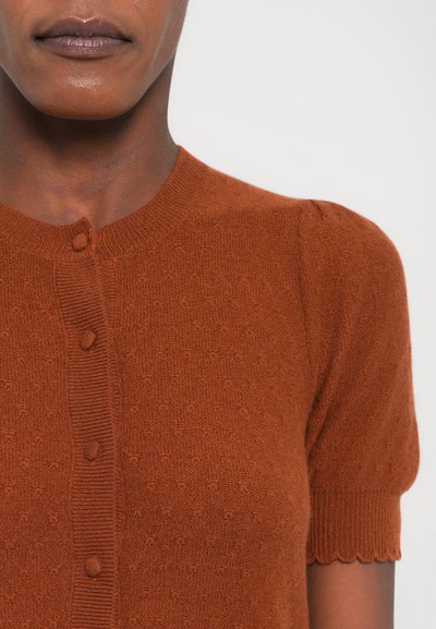 Rust-colored knitted cardigan with short sleeves, round neckline, and button-down front. Features subtle textured pattern and ribbed accents.