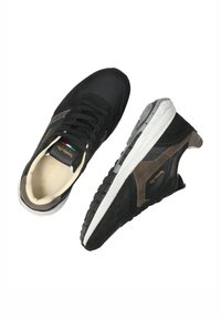 Sneaker nere e marroni con un mix di materiali in rete e suede, suola in gomma bianca e lacci. Presenta un branding sottile e un design classico.